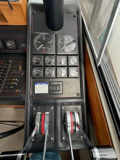 Slide: The Image of 1990 Bayliner 3888 Motoryacht dashboard with control levers and gauges. - 20