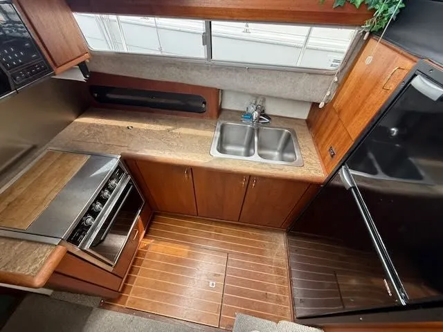 Slide: The Image of Interior of 1990 Bayliner 3888 Motoryacht with kitchen and wood finish. - 22