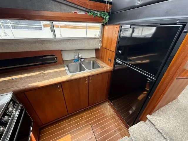 Slide: The Image of 1990 Bayliner 3888 Motoryacht kitchen with sink and refrigerator. - 24
