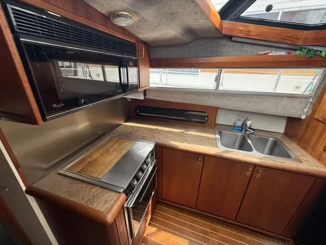 Slide: The Image of 1990 Bayliner 3888 Motoryacht kitchen with wood cabinets and stainless steel sink. - 25