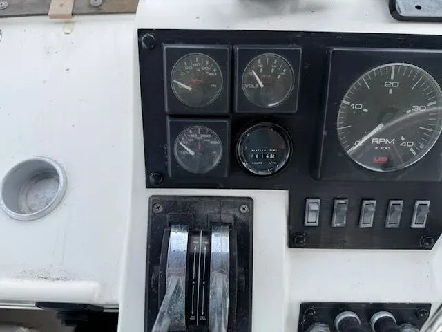 Slide: The Image of 1990 Bayliner 3888 Motoryacht dashboard with tachometer and switches. - 44