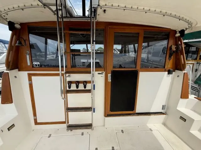 Slide: The Image of 1990 Bayliner 3888 Motoryacht, rear view with ladder and wooden doors. - 6