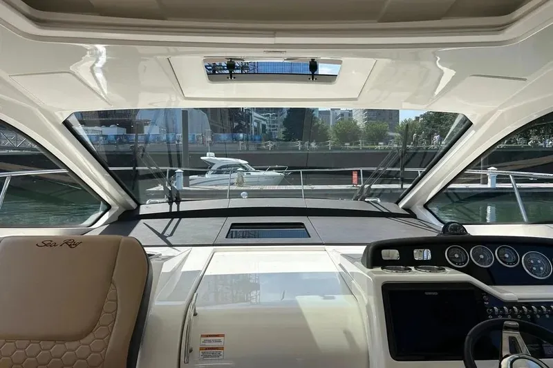 Slide: The Image of Interior view of 2019 Sea Ray Sundancer 350 Coupe yacht cockpit with cityscape background. - 11