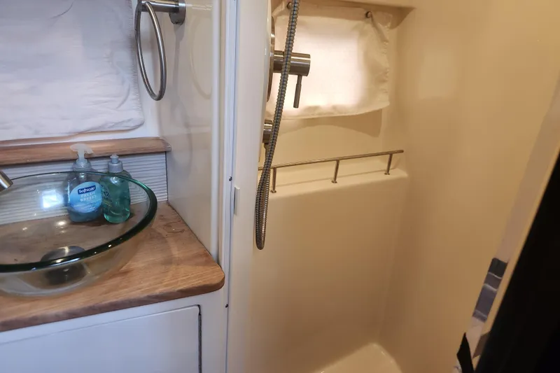 Slide: The Image of 2019 Sea Ray Sundancer 350 Coupe bathroom with glass sink and shower area. - 16
