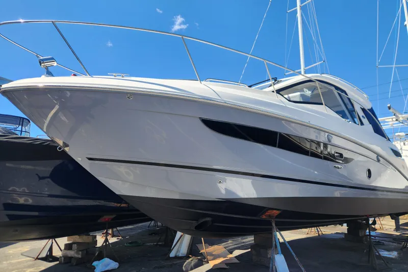 Slide: The Image of 2019 Sea Ray Sundancer 350 Coupe yacht on dry dock under clear blue sky. - 4