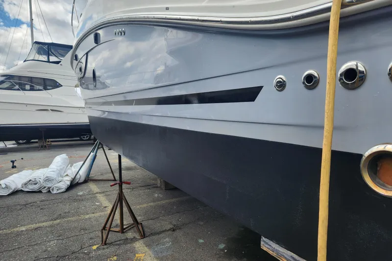 Slide: The Image of 2019 Sea Ray Sundancer 350 Coupe on dry dock, showcasing sleek hull design. - 5