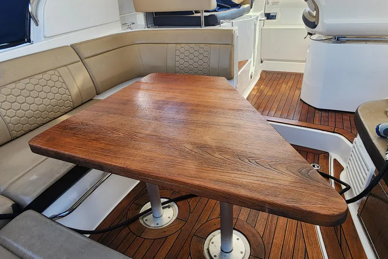 Slide: The Image of Interior of 2019 Sea Ray Sundancer 350 Coupe with wooden table and cushioned seating. - 9