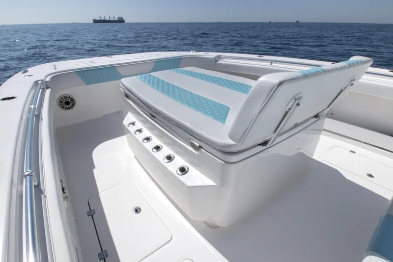 Slide: The Image of 2019 Invincible 40 Catamaran interior with cushioned seating, ocean view, and distant ship. - 20