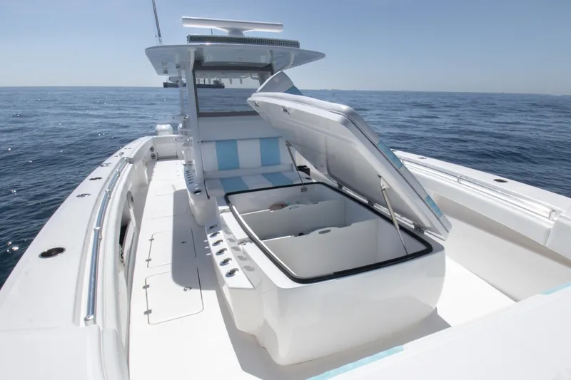 Slide: The Image of 2019 Invincible 40 Catamaran with open storage, sleek design, and ocean backdrop. - 23