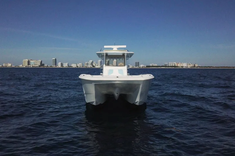 Slide: The Image of 2019 Invincible 40 Catamaran on open water with city skyline in background. - 4