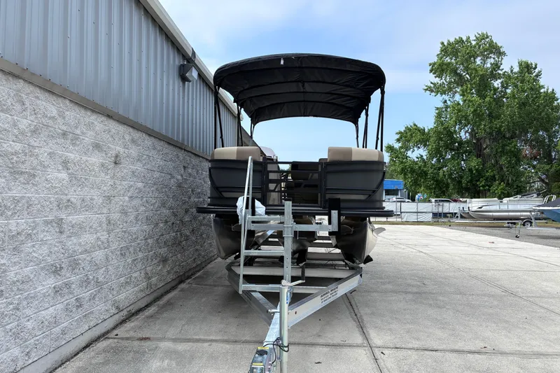 Slide: The Image of 2026 Starcraft EXS 1 Q DH pontoon boat on trailer, parked outdoors. - 3