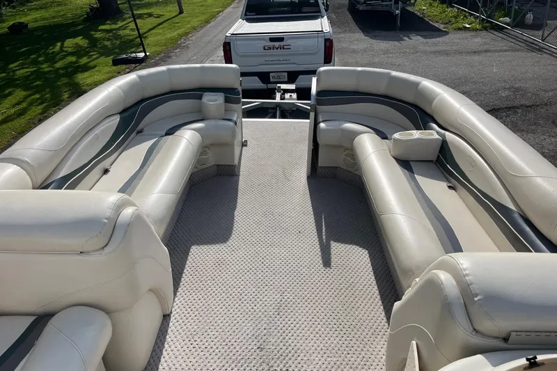 Slide: The Image of 2004 Bennington 2250RL pontoon boat interior with plush seating and cup holders. - 11