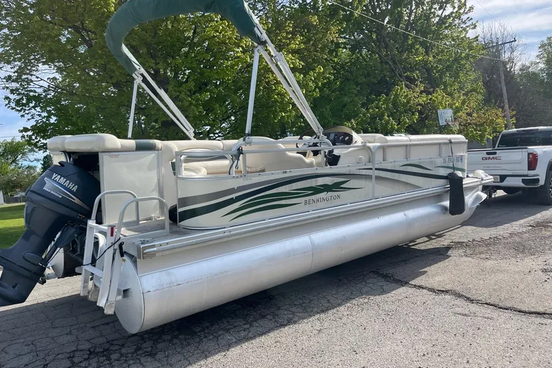 Slide: The Image of 2004 Bennington 2250RL pontoon boat with Yamaha motor, parked near a GMC truck. - 12