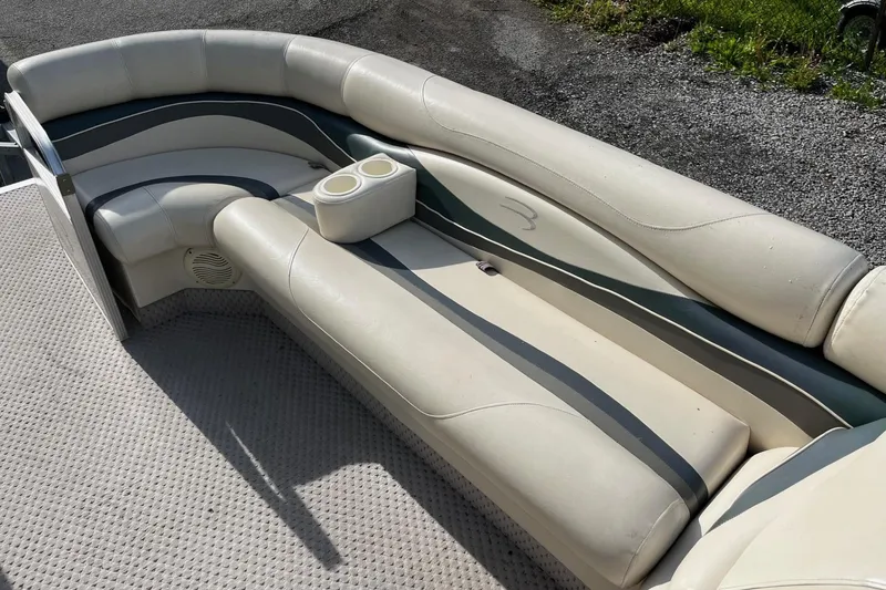 Slide: The Image of 2004 Bennington 2250RL boat interior with beige seating and cup holders. - 3