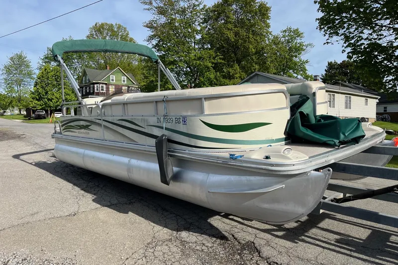 Slide: The Image of 2004 Bennington 2250RL pontoon boat on trailer, parked in residential area. - 8