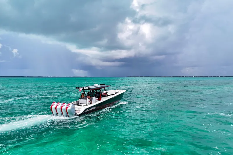 Slide: The Image of 2026 Nor-Tech 390 Sport Center Console cruising on turquoise ocean under cloudy sky. - 10