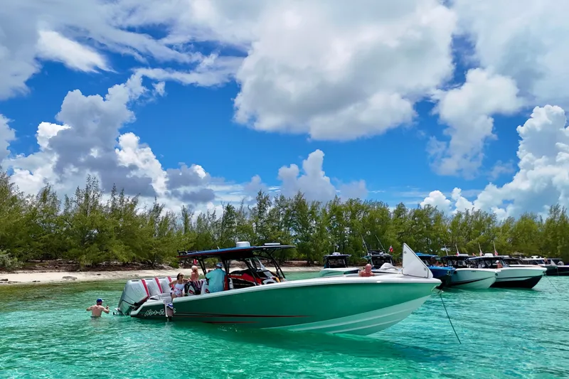 Slide: The Image of 2026 Nor-Tech 390 Sport Center Console in turquoise waters near a lush island. - 14
