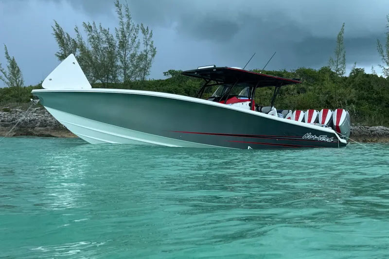 Slide: The Image of 2026 Nor-Tech 390 Sport Center Console boat in turquoise water near lush shoreline. - 15