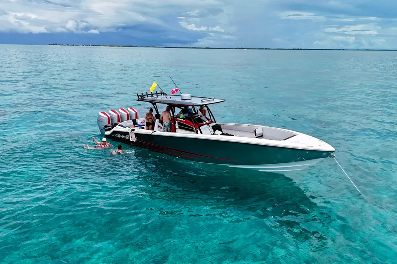 Slide: The Image of 2026 Nor-Tech 390 Sport Center Console on clear blue water with swimmers nearby. - 6