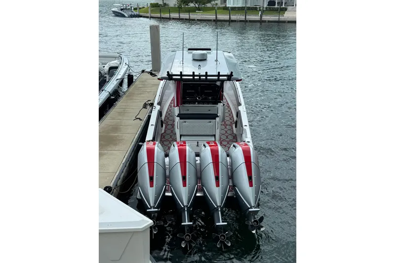 Slide: The Image of 2026 Nor-Tech 390 Sport Center Console with four powerful outboard engines docked by the water. - 7