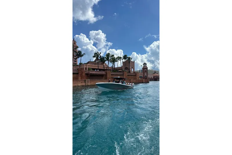 Slide: The Image of 2026 Nor-Tech 390 Sport Center Console cruising near a scenic waterfront with palm trees. - 8