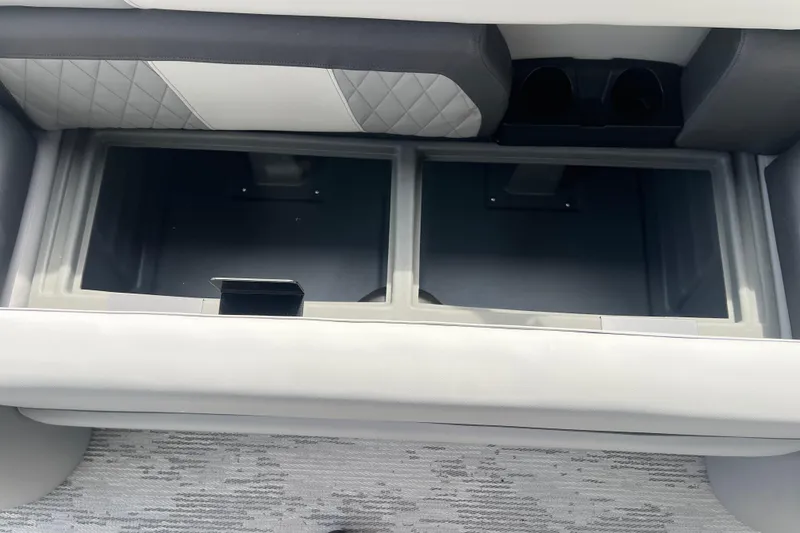 Slide: The Image of 2026 Starcraft EXS 3 FD boat storage compartment with quilted upholstery and dual cup holders. - 25