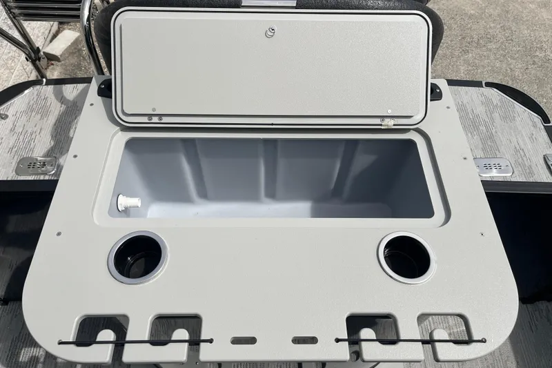 Slide: The Image of Open storage compartment on 2026 Starcraft EXS 3 FD boat, featuring cup holders and utility slots. - 27