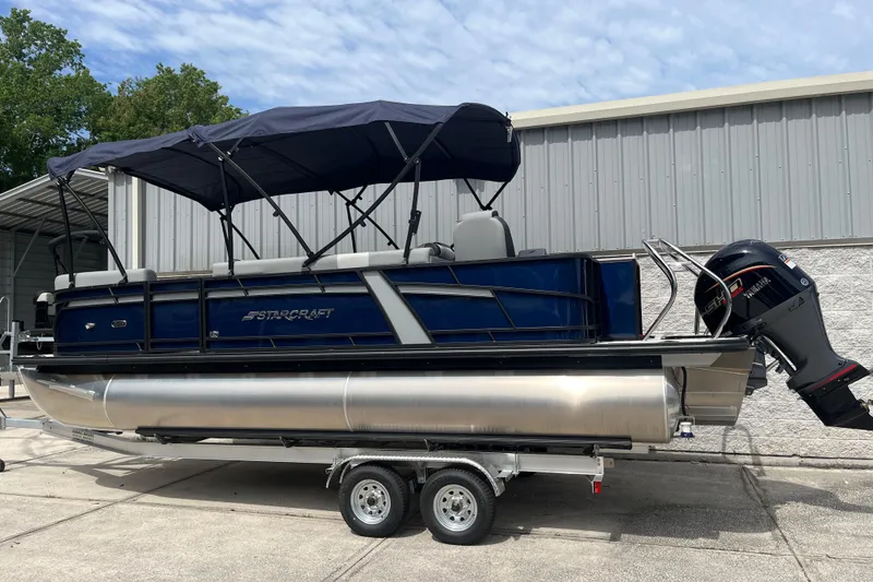 Slide: The Image of 2026 Starcraft EXS 3 FD pontoon boat with canopy and outboard motor on trailer. - 33