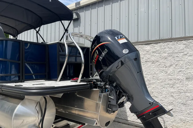 Slide: The Image of 2026 Starcraft EXS 3 FD boat with Yamaha 175 outboard motor, docked near a metal building. - 34