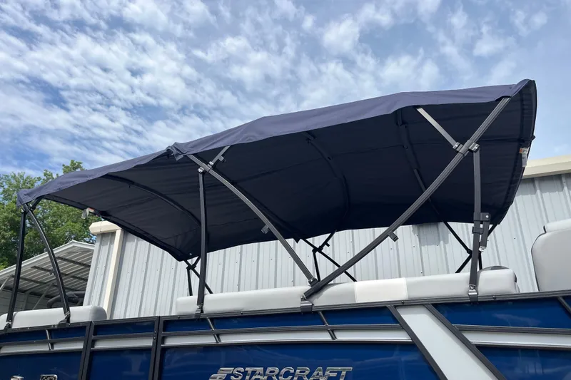 Slide: The Image of 2026 Starcraft EXS 3 FD boat with blue canopy under a partly cloudy sky. - 43