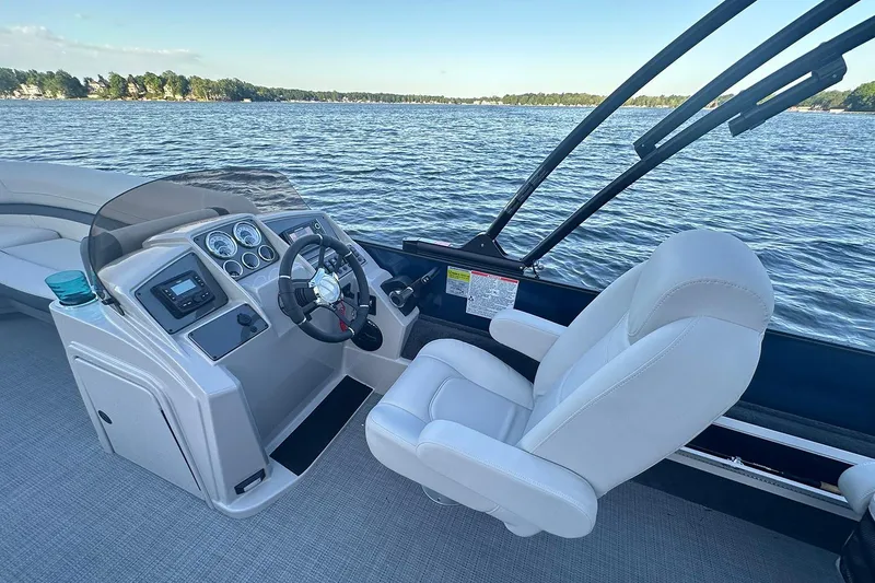 Slide: The Image of Manufacturer Provided Image: 2026 Starcraft EXS 3 FD boat interior with steering wheel and dashboard, overlooking serene lake. - 6