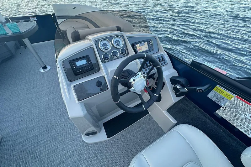 Slide: The Image of Manufacturer Provided Image: 2026 Starcraft EXS 3 FD boat dashboard with steering wheel and control panel on water. - 7