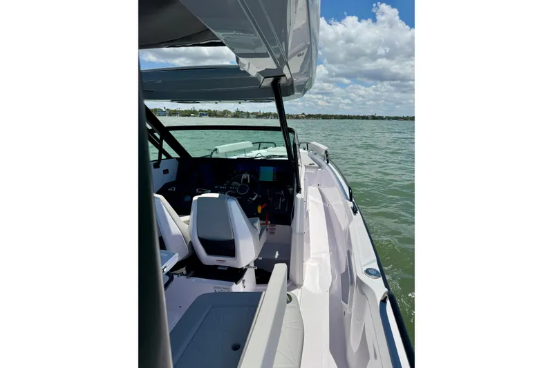 Slide: The Image of 2025 Axopar 29 Sun-Top boat interior with helm, seats, and open water view. - 10