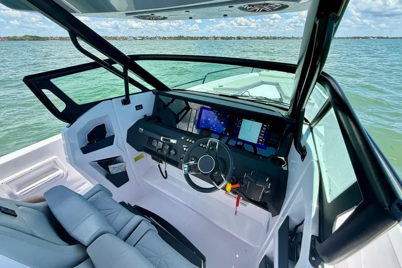 Slide: The Image of 2025 Axopar 29 Sun-Top boat interior with modern dashboard and steering wheel. - 11