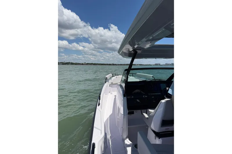 Slide: The Image of 2025 Axopar 29 Sun-Top boat cruising on a sunny day with clear skies. - 13