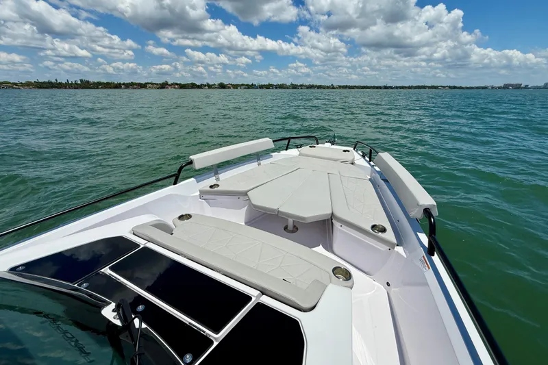 Slide: The Image of 2025 Axopar 29 Sun-Top boat on calm water under a partly cloudy sky. - 15