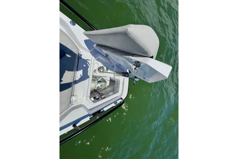 Slide: The Image of 2025 Axopar 29 Sun-Top boat anchor compartment with open hatch on green water. - 18