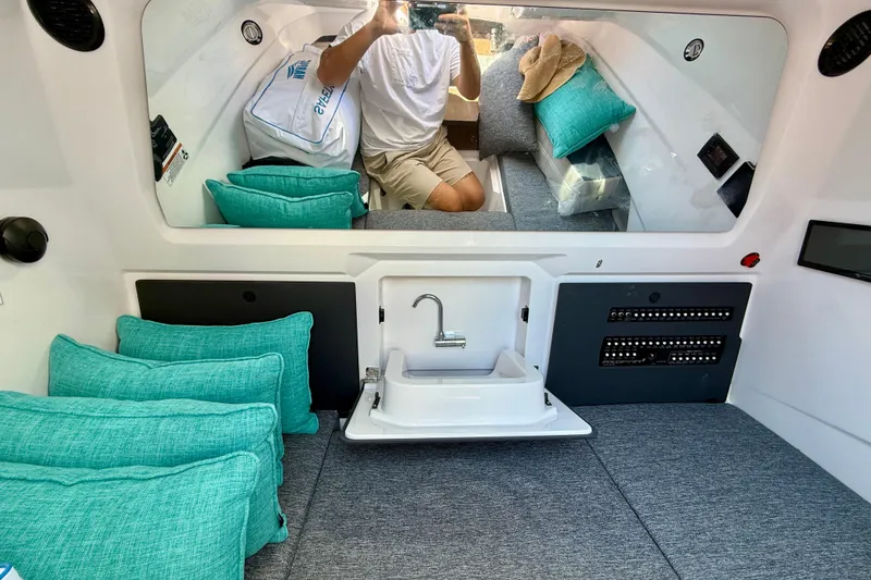 Slide: The Image of Interior of 2025 Axopar 29 Sun-Top boat with teal cushions and compact sink. - 21