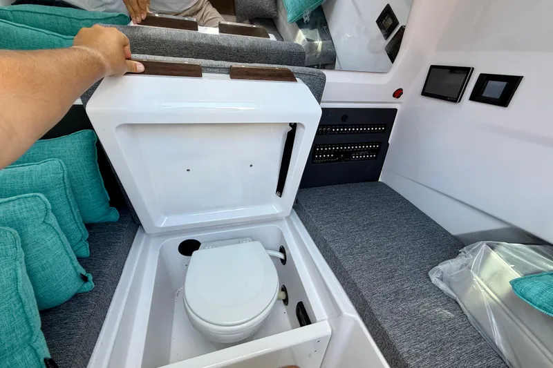 Slide: The Image of 2025 Axopar 29 Sun-Top boat interior with hidden toilet compartment and seating area. - 22
