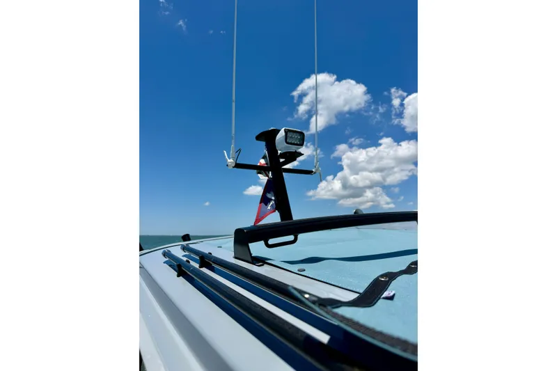 Slide: The Image of 2025 Axopar 29 Sun-Top boat with clear blue sky and clouds in the background. - 24