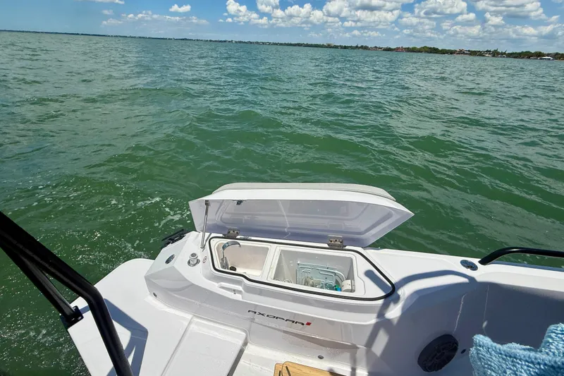 Slide: The Image of 2025 Axopar 29 Sun-Top boat on water, open storage compartment visible. - 4