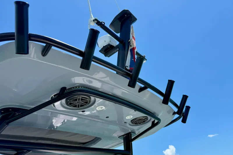 Slide: The Image of 2025 Axopar 29 Sun-Top boat roof with rod holders against blue sky. - 6