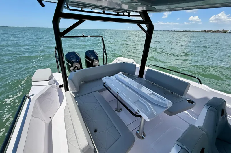 Slide: The Image of 2025 Axopar 29 Sun-Top boat interior with seating and table on open water. - 7