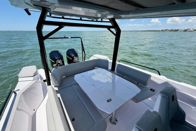 Slide: The Image of 2025 Axopar 29 Sun-Top boat with seating and table on open water. - 8