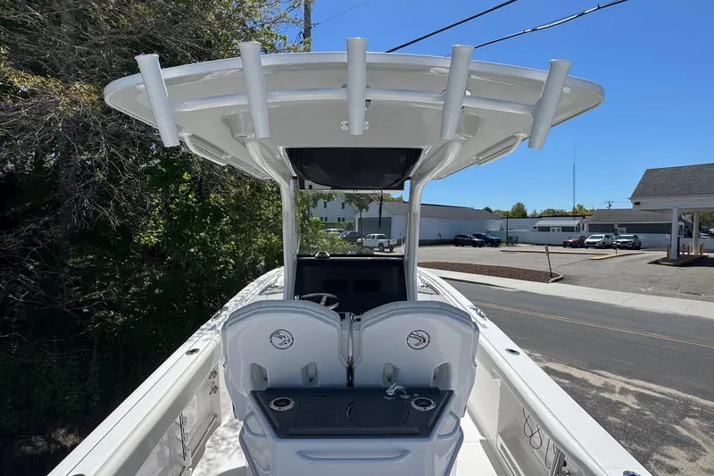 Slide: The Image of 2026 Edgewater 262CC boat with T-top and dual helm seats, parked outdoors. - 15