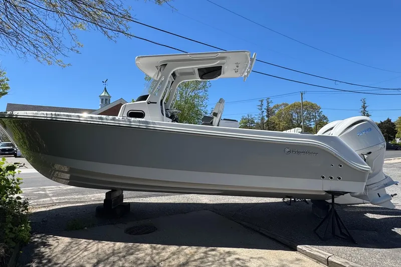 Slide: The Image of 2026 Edgewater 262CC boat displayed outdoors on a sunny day. - 2
