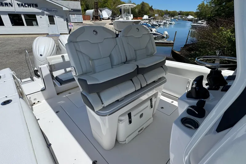 Slide: The Image of 2026 Edgewater 262CC boat interior with dual seats and helm, docked near marina. - 26