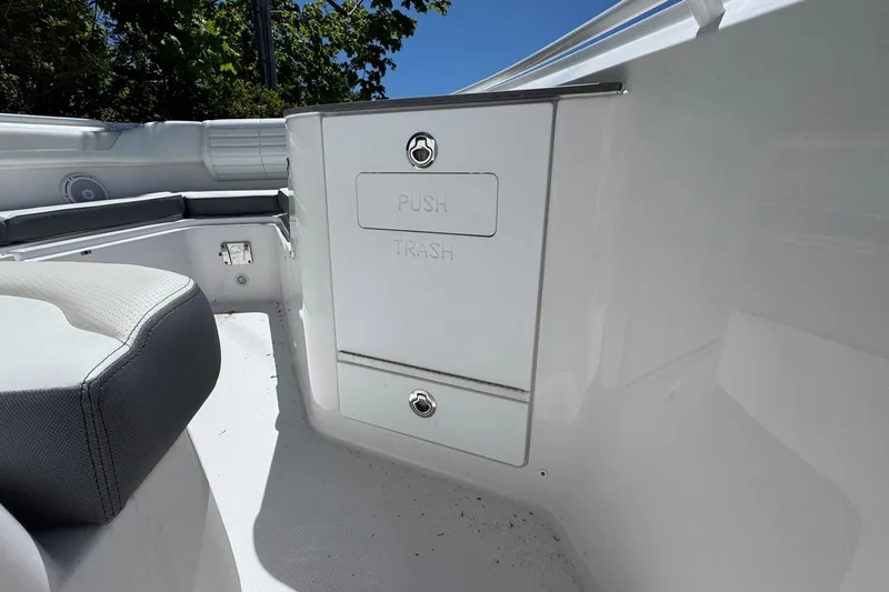 Slide: The Image of Interior of 2026 Edgewater 262CC boat showing trash compartment and seating area. - 32