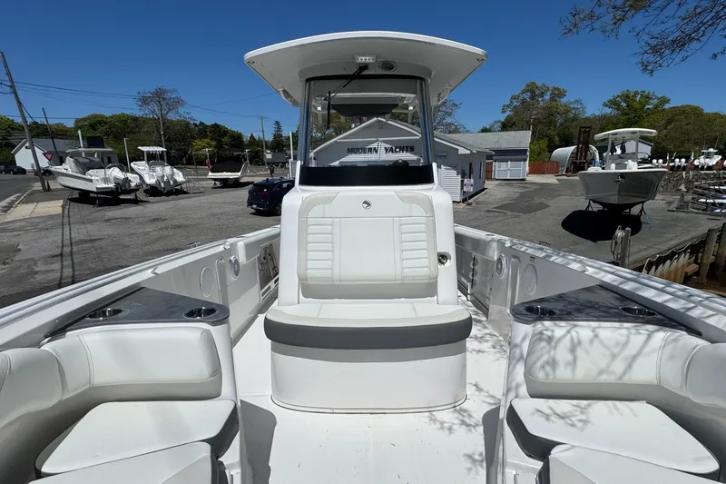 Slide: The Image of 2026 Edgewater 262CC boat with sleek seating and modern design at a marina. - 36