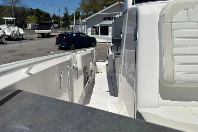 Slide: The Image of 2026 Edgewater 262CC boat interior with white seating, parked in a marina. - 40